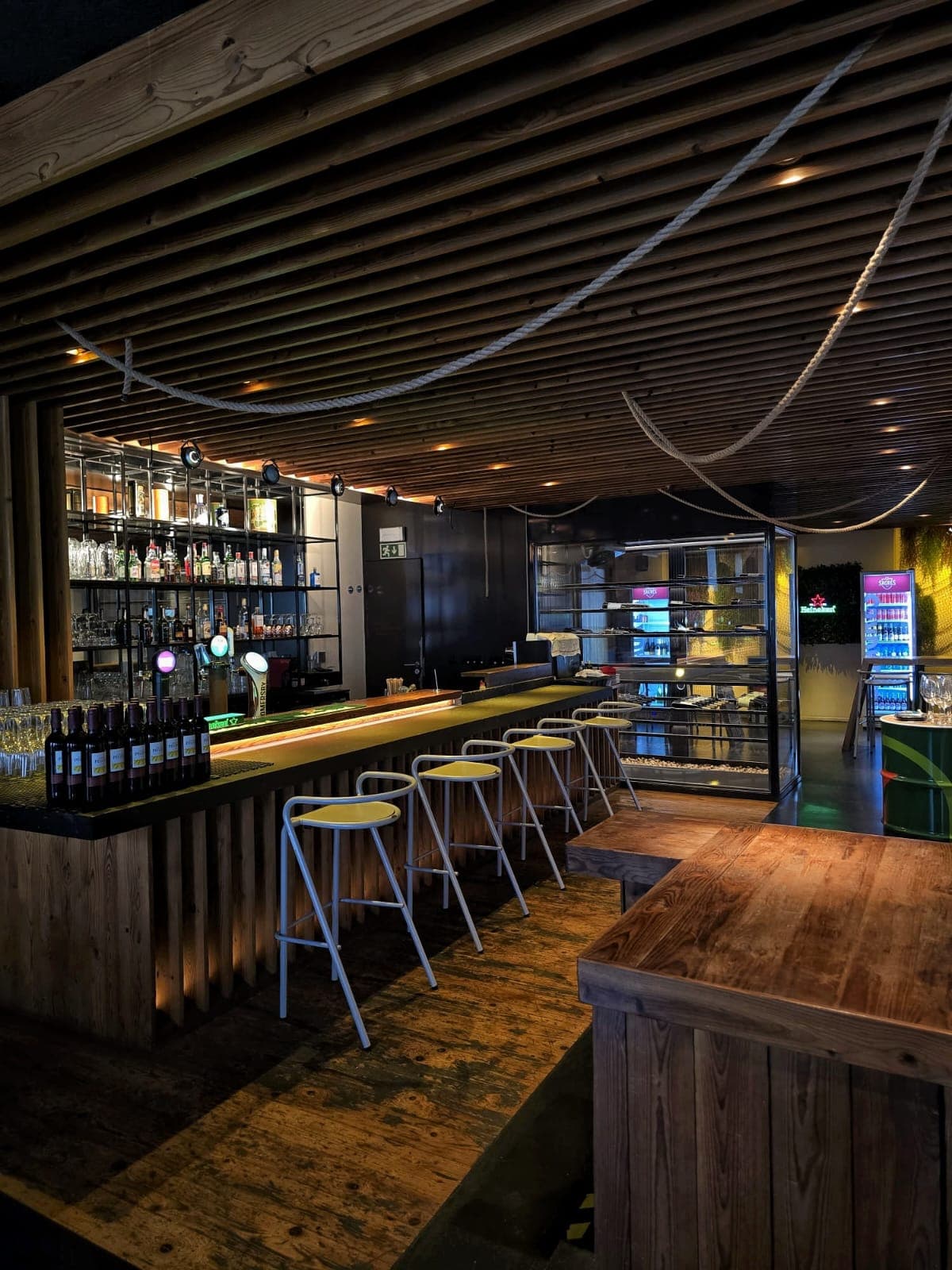 Bar da Taberna Tuga com luz quente e apontamentos azuis no Cais do Sodré